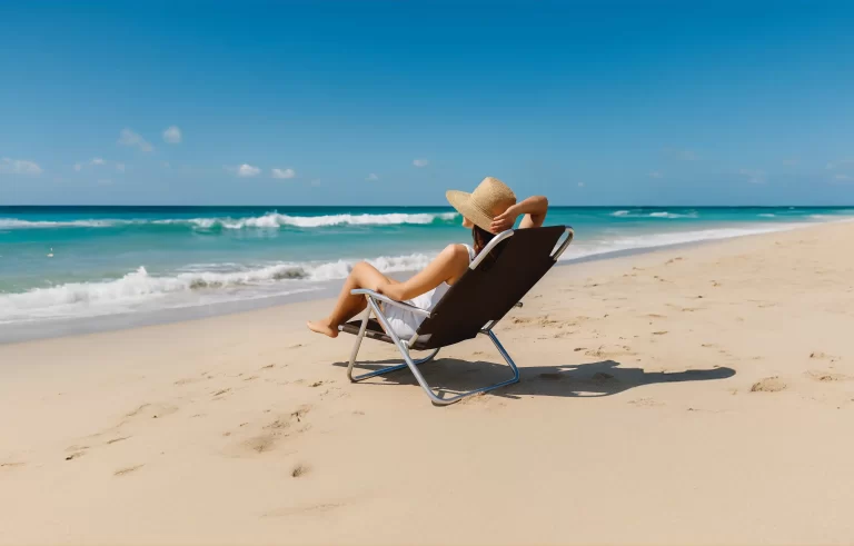 Imagem de uma cadeira na praia com uma mulher sentada relaxando e apreciando a vista