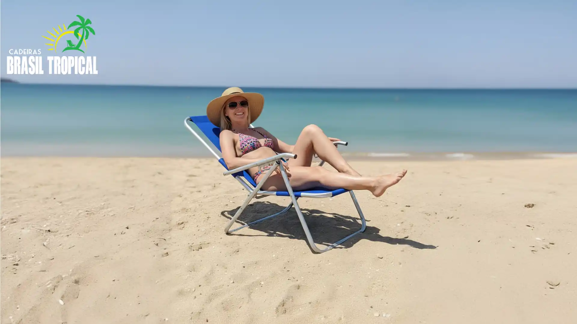 Mulher loira sentada em uma cadeira de praia azul reclinada, a mulher está usando trajes de banho, um chapéu e óculos escuros.